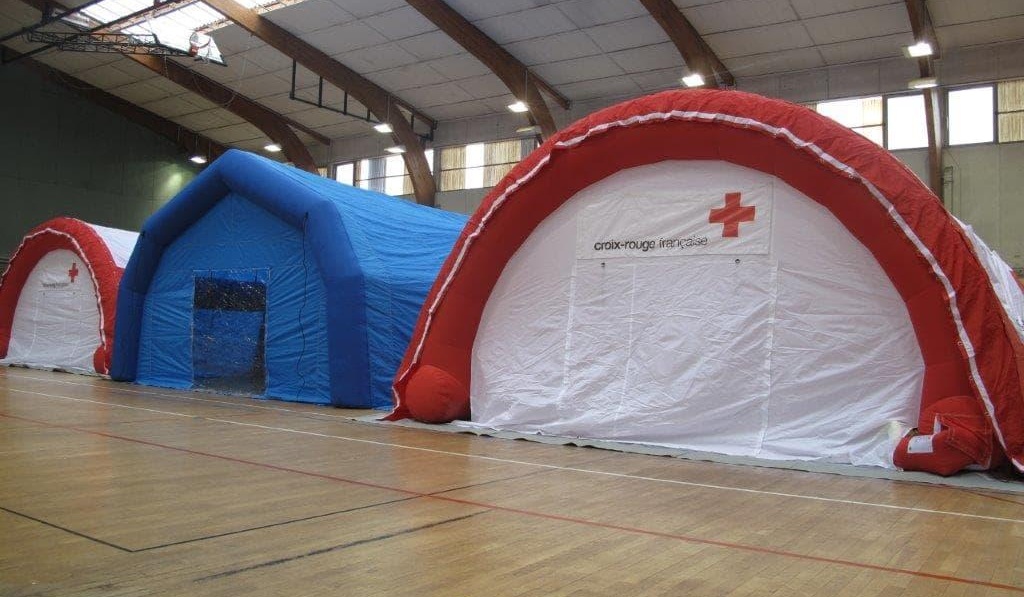 Example of a first aid station in the shape of a half-moon tunnel, for the French Red Cross, an inflatable structure ventilated by a turbine at all times, with removable printed banners attached with Velcro strips.