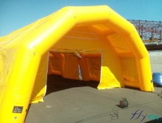 View of the front facade, the front gable with a large door and a canopy of an inflatable medical tent, a mobile first aid station, or field hospital, a captive air inflatable structure, inflated with air with an electric pump.
