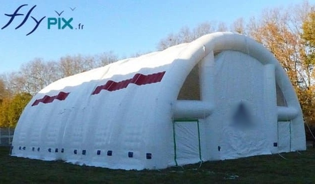 A large inflatable military aeronautical shed hangar, half-moon tunnel shape, entirely in padded double-skin PVC envelope, a large inflatable structure composed of 2 modules connected together.