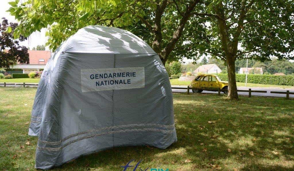 Exterior view of a military tent, an inflatable marquee made for the French National Gendarmerie, a captive air inflatable structure inflated with air using an electric pump, removable marking banners, Velcro fasteners and reflective safety strips for nighttime use.