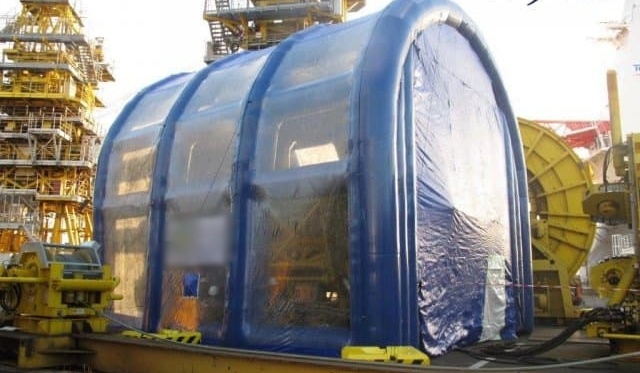 Exterior view of an inverted U-shaped inflatable shed, for the maintenance and repair of a very large generator or engine in a confined space.