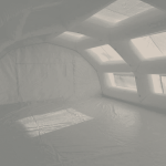 An interior view of the inflatable first aid station shelter manufactured for the SAMU (Emergency Medical Service) of the Evreux Hospital Center , providing a very large space, a very large surface area, and a very large usable work volume for medical staff and doctors. A PVC-coated tarpaulin floor creates a clean, hygienic, and moisture-free first aid area. The tarpaulin also provides better thermal insulation and protects against moisture rising from the ground. The usable interior space is ideal for accommodating a significant number of patients and can be furnished with folding medical beds, desks, etc. – Copyright Vivien LAÏLLE / FlyPix – All rights reserved, reproduction prohibited.