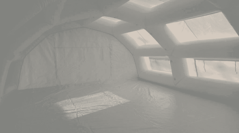 An interior view of the inflatable first aid station shelter manufactured for the SAMU (Emergency Medical Service) of the Evreux Hospital Center , providing a very large space, a very large surface area, and a very large usable work volume for medical staff and doctors. A PVC-coated tarpaulin floor creates a clean, hygienic, and moisture-free first aid area. The tarpaulin also provides better thermal insulation and protects against moisture rising from the ground. The usable interior space is ideal for accommodating a significant number of patients and can be furnished with folding medical beds, desks, etc. – Copyright Vivien LAÏLLE / FlyPix – All rights reserved, reproduction prohibited.