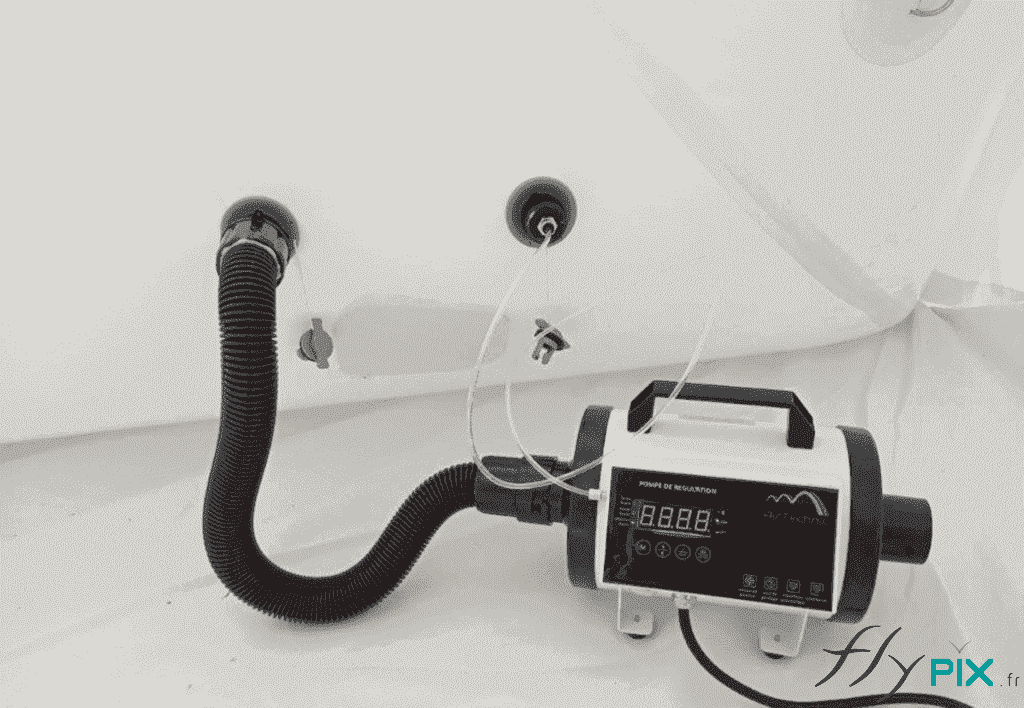 The kit includes an electric pump and a pressure regulator, two essential accessories for inflating the PMA inflatable tent. The photo shows an example of a pressure regulator. Inflating a captive air shelter involves two steps: first, inflation with the electric pump to the required air capacity, and then connecting the pressure regulator. This regulator modulates and manages the pressure inside the inflatable tubes, adding or removing air depending on the pressure and ambient temperature. It stabilizes the air pressure within the tubes to compensate for the expansion or contraction of the inflatable structure. In addition to this device, there are overpressure and safety valves that expel air from the tubes in case of excessively rapid expansion. They will " psst " – Copyright Vivien LAÏLLE / FlyPix – All rights reserved, reproduction prohibited.