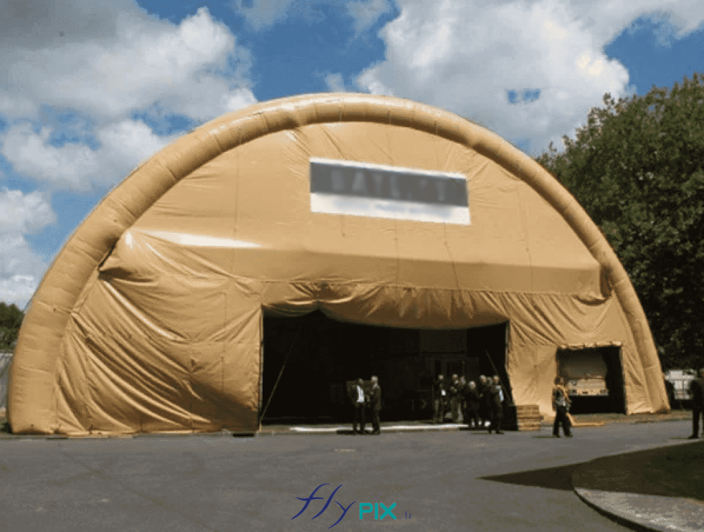 NEXTER: a large inflatable military hangar, in double-skinned padded PVC envelope, providing a large volume, a large surface area and a large height, for the storage of equipment, vehicles or offices for the military operations of our armed forces and for military personnel in the context of military operations or deployments. – All rights reserved, copyright FLYPIX.