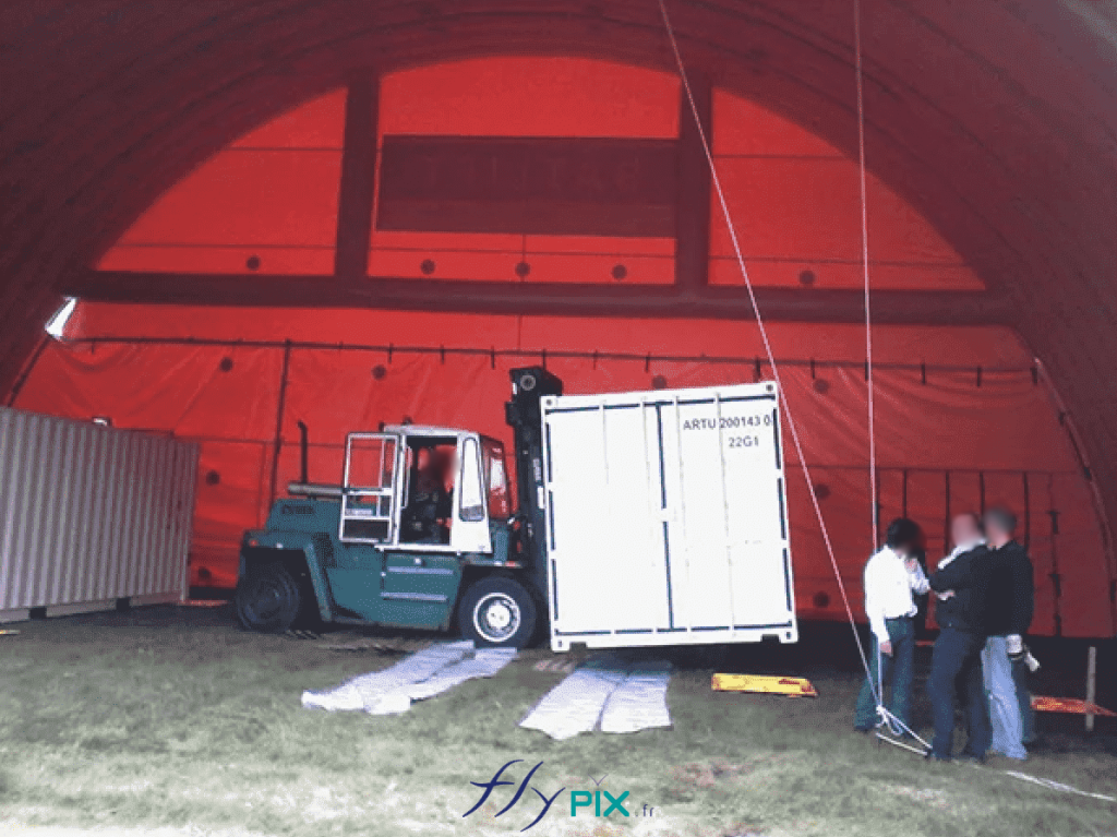 NEXTER: Technicians are positioning containers inside a large inflatable military hangar, shaped like a tunnel. – All rights reserved, copyright FLYPIX.