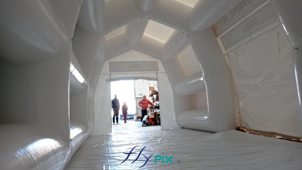 Another photo taken from inside the inflatable medical tent. Note the internal metal rings and eyelets distributed along the frame tubes, allowing for the suspension of lightweight and useful first aid equipment for patients, injured persons, or victims. – All rights reserved, reproduction prohibited. Copyright FlyPix / Vivien LAÏLLE. Another photo taken from inside the inflatable medical tent. Note the internal metal rings and eyelets distributed along the frame tubes, allowing for the suspension of lightweight and useful first aid equipment for patients, injured persons, or victims. – All rights reserved, reproduction prohibited. Copyright FlyPix / Vivien LAÏLLE.