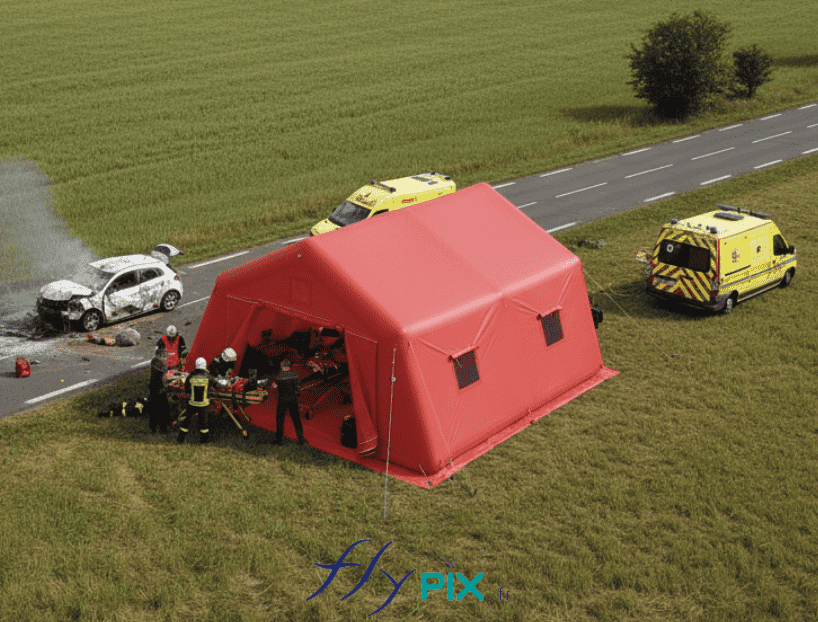 This aerial view is a simulation illustrating the concept of a field intervention using an inflatable advanced medical post shelter for providing first aid and emergency relief, in this case, at a road accident. The inflatable medical tent was custom-made by us in our workshops in Orléans, France. This particular inflatable medical shelter has a usable surface area of ​​37 m² and is shaped like angled panels. It is airtight, with sealed frame tubes, meaning it is inflated with air using an electric pump. This inflatable structure is self-supporting and inflates all at once. It can be deployed in an emergency at any site within minutes. This image was AI-generated using GEMINI, based on 3D model views of the final proof created by our graphic designer and approved by the client, as well as photos and real - life shots of certain details of the inflatable tent, taken directly in our manufacturing workshop. Media partially generated by AI and verified by an agent. – Copyright Vivien LAÏLLE/FlyPix, all rights reserved, reproduction prohibited.
