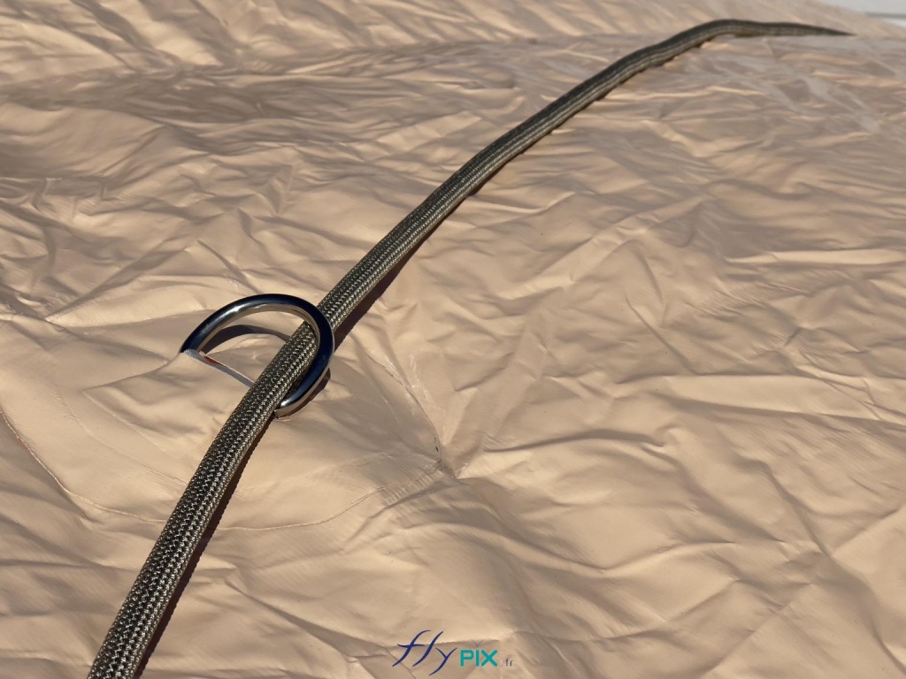Several metal rings are fixed at various points along the radius of curvature of the semi-circular tunnel-shaped inflatable structures. Through these rings, we thread Lancelin marine-grade ropes, approximately 1 cm in diameter, which are very strong and robust. These ropes are used to ballast the different modules of the inflatable hangar. The halyards are then attached to the ballast, which consists of large bags to be filled with sand. - Copyright: Vivien LAÏLLE/FLYPIX, all rights reserved. Several metal rings are fixed at various points along the radius of curvature of the semi-circular tunnel-shaped inflatable structures. Through these rings, we thread Lancelin marine-grade ropes, approximately 1 cm in diameter, which are very strong and robust. These ropes are used to ballast the different modules of the inflatable hangar. The halyards are then attached to the ballast, which consists of large bags to be filled with sand. – Copyright: Vivien LAÏLLE/FLYPIX, all rights reserved.
