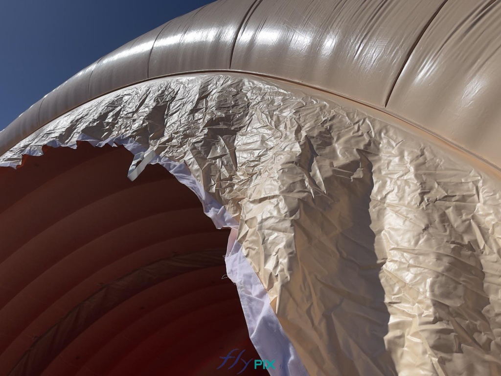 Each module of the inflatable military hangar features an interface consisting of a tarpaulin that allows for the assembly of two modules and ensures a watertight seal thanks to an internal connection. This photo shows the connection and the fasteners that secure the joining and junction of two inflatable modules. - Copyright: Vivien LAÏLLE/FLYPIX, all rights reserved. Each module of the inflatable military hangar features an interface consisting of a tarpaulin that allows for the assembly of two modules and ensures a watertight seal thanks to an internal connection. This photo shows the connection and the fasteners that secure the joint and connection of two inflatable modules. – Copyright: Vivien LAÏLLE/FLYPIX, all rights reserved.