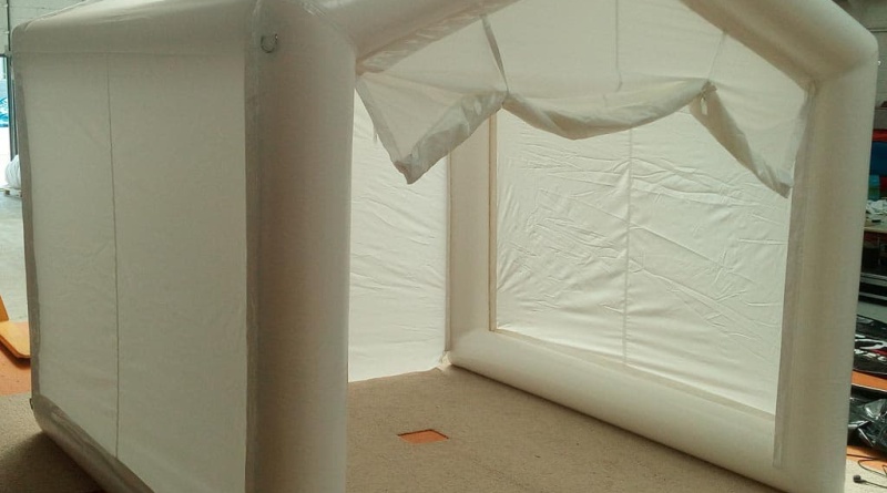 General view of the inflatable tent: the wide gable door at the front is open, the non-return inflation valve is at the bottom left, and on the upper part are metal attachment rings for guy lines, for use in outdoor environments. – All rights reserved, reproduction prohibited. Copyright FlyPix / Vivien LAÏLLE.